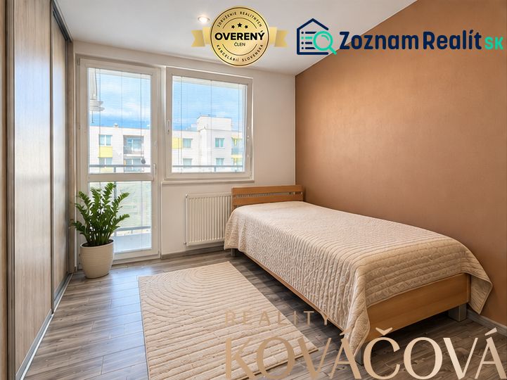 A room of a 4-room apartment with a wooden decor floor and a bed.