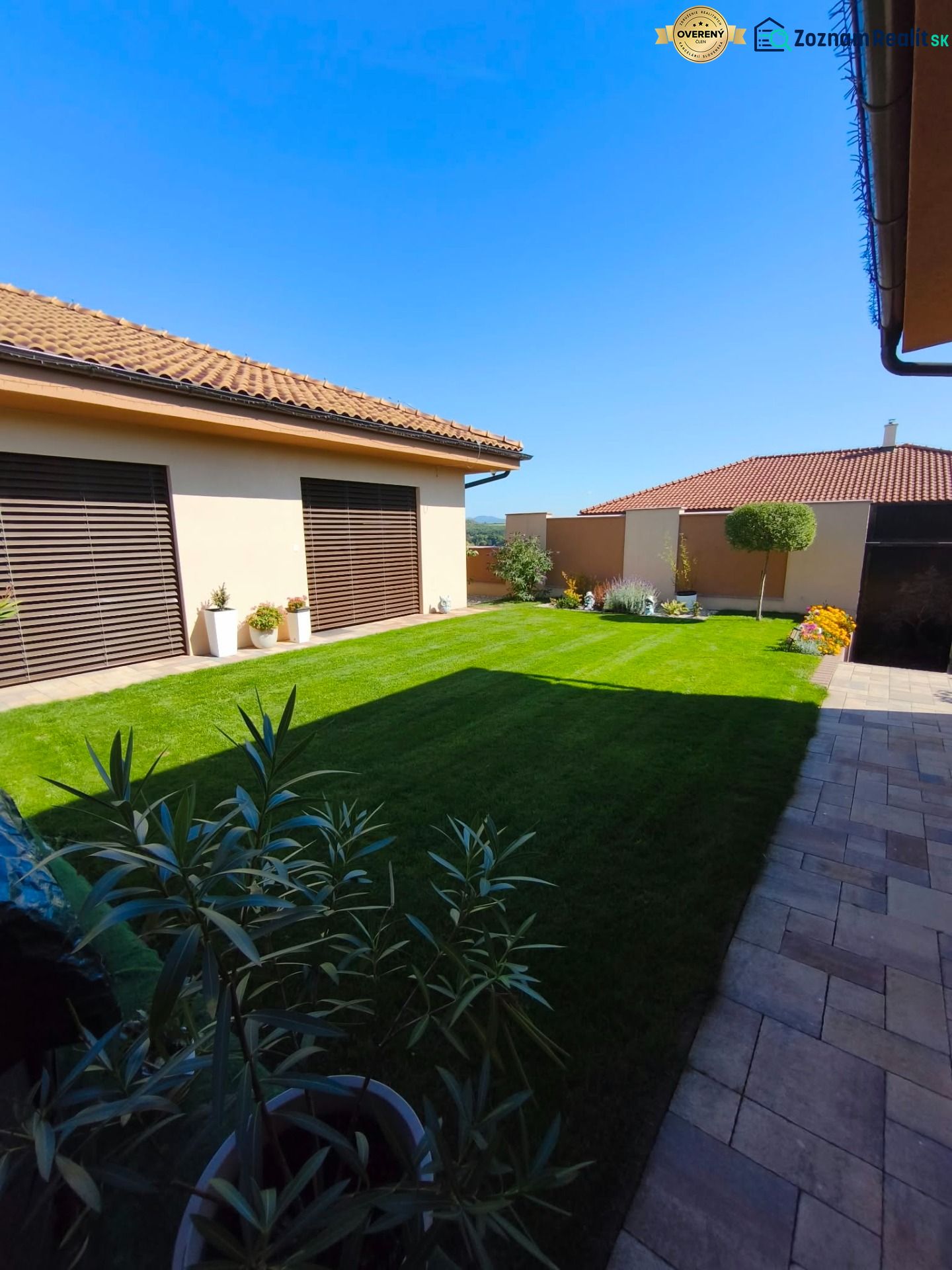 The garden of a family house in Martin nad Žitavou with a lawn and a terrace.
