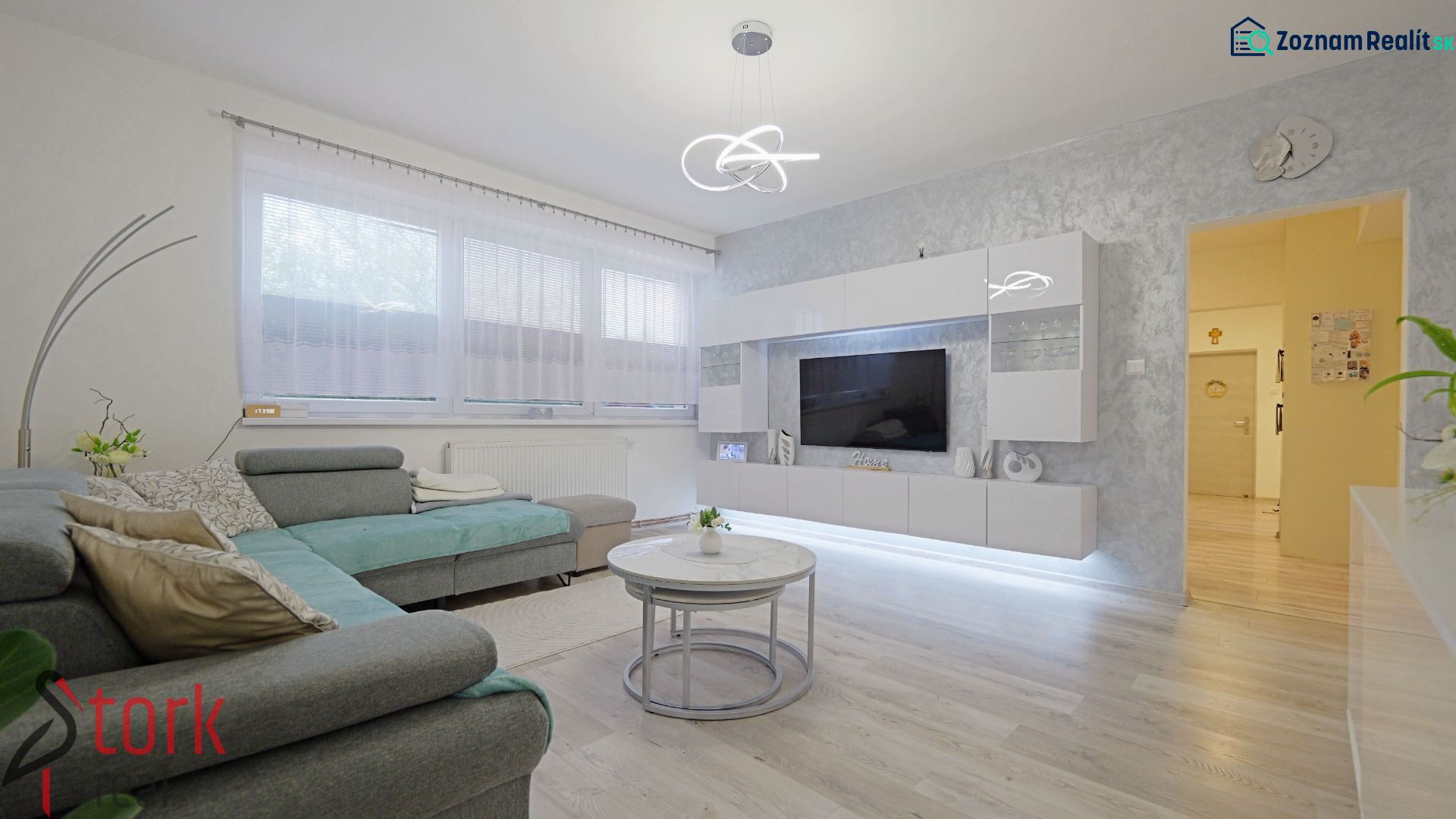 Living room in a 4-room apartment with a wooden decor floor and a comfortable sofa.