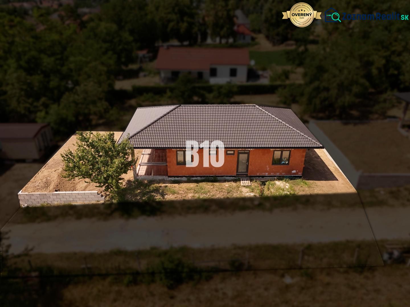 A family house in Čeľadice with a brick facade, a sloped roof, and fencing.