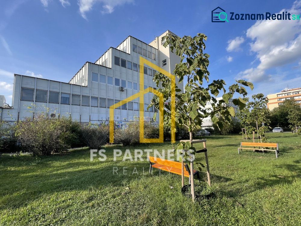 Offices on Záhradnícka Street in Komárno with benches and young trees.