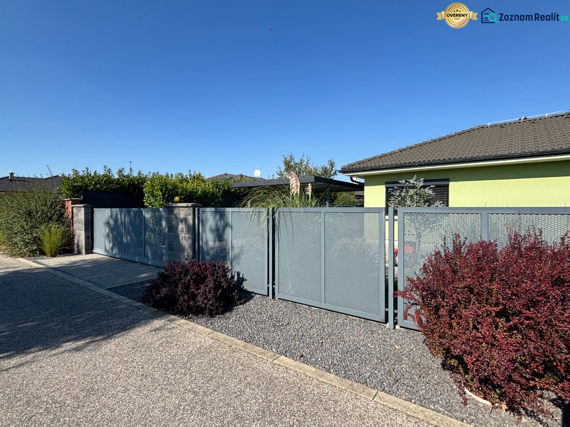 A family house on Figová Street in Bernolákovo with a metal fence and a landscaped garden.