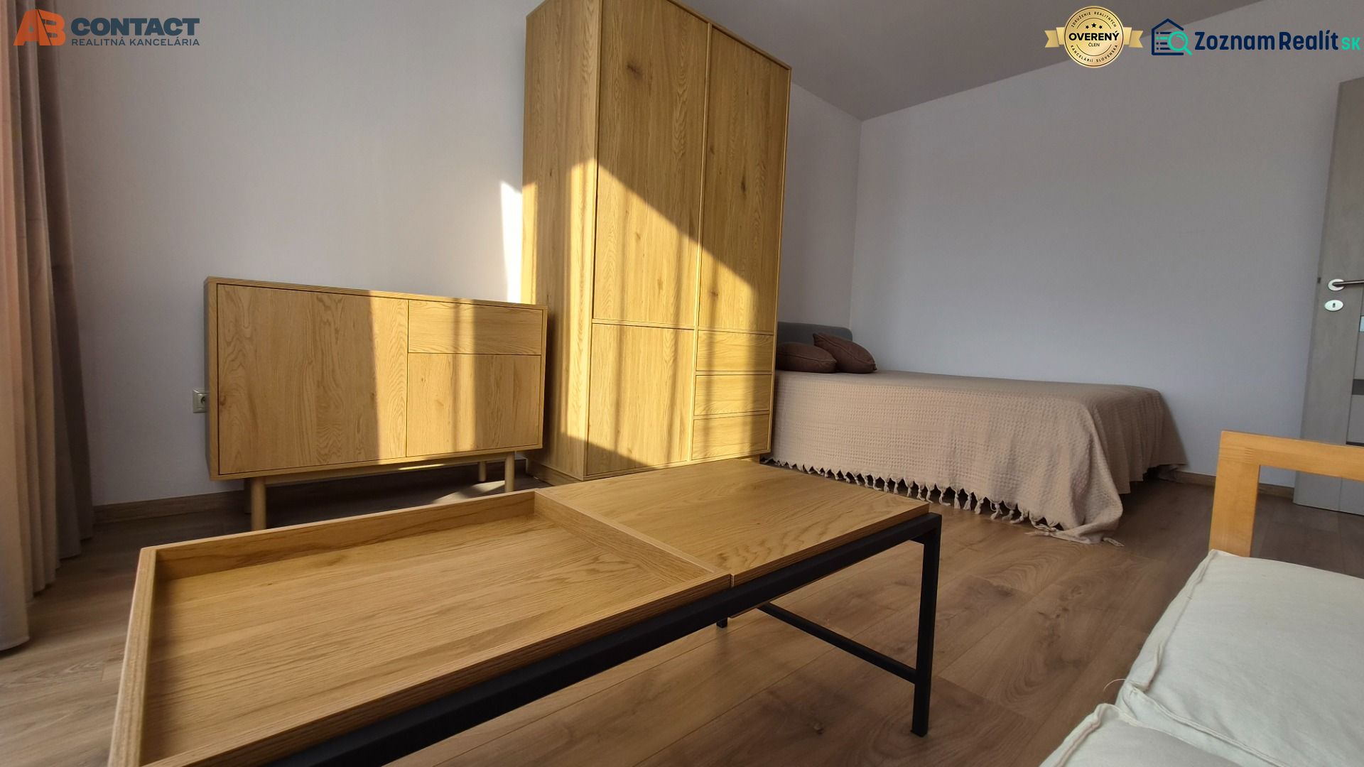 Interior of a 1-room apartment with a bed, wooden furniture, and a floor with a wood decor.