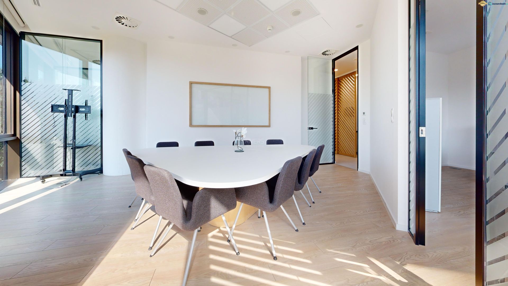 Meeting in the office at an oval table, wooden decor flooring.