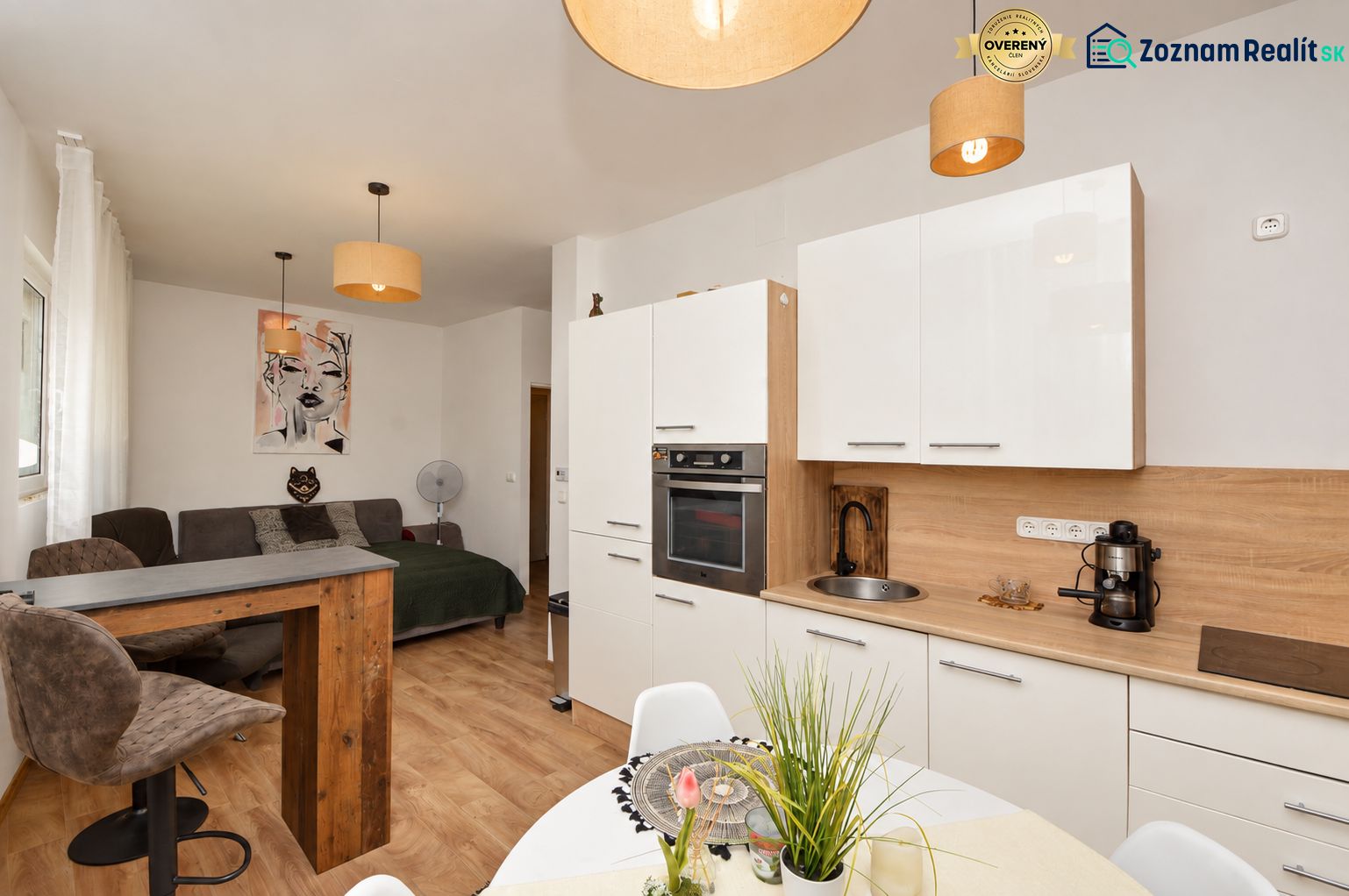 Interior of a 1-room apartment with a kitchen unit and a wooden decor floor.