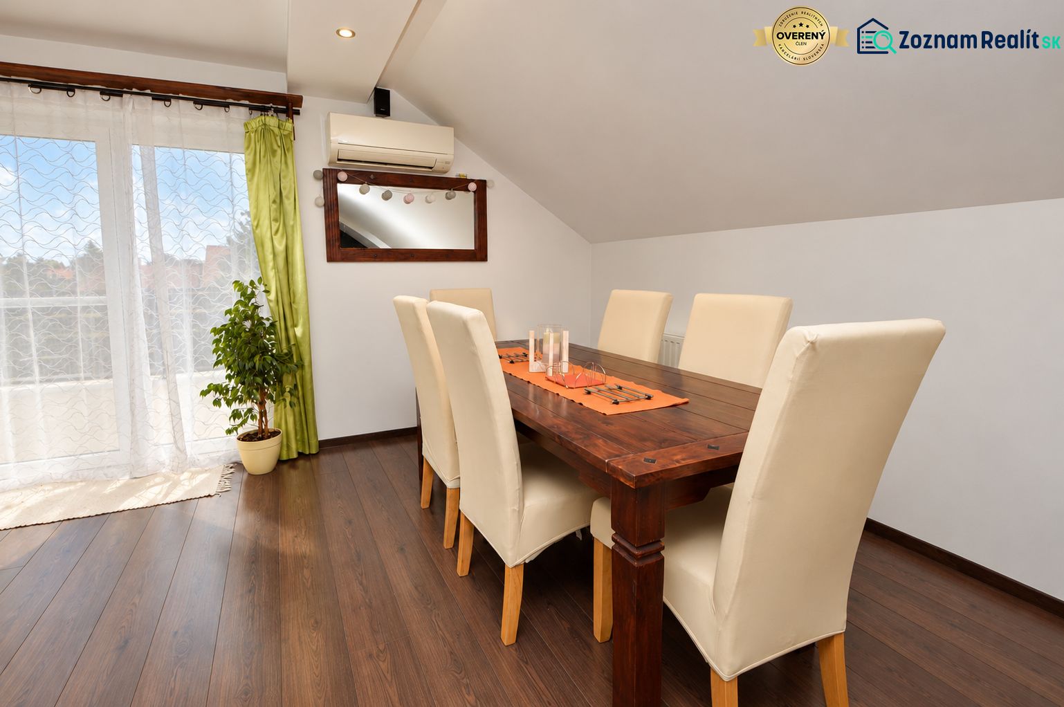 Dining room in a family house with a wooden decor floor and large windows.
