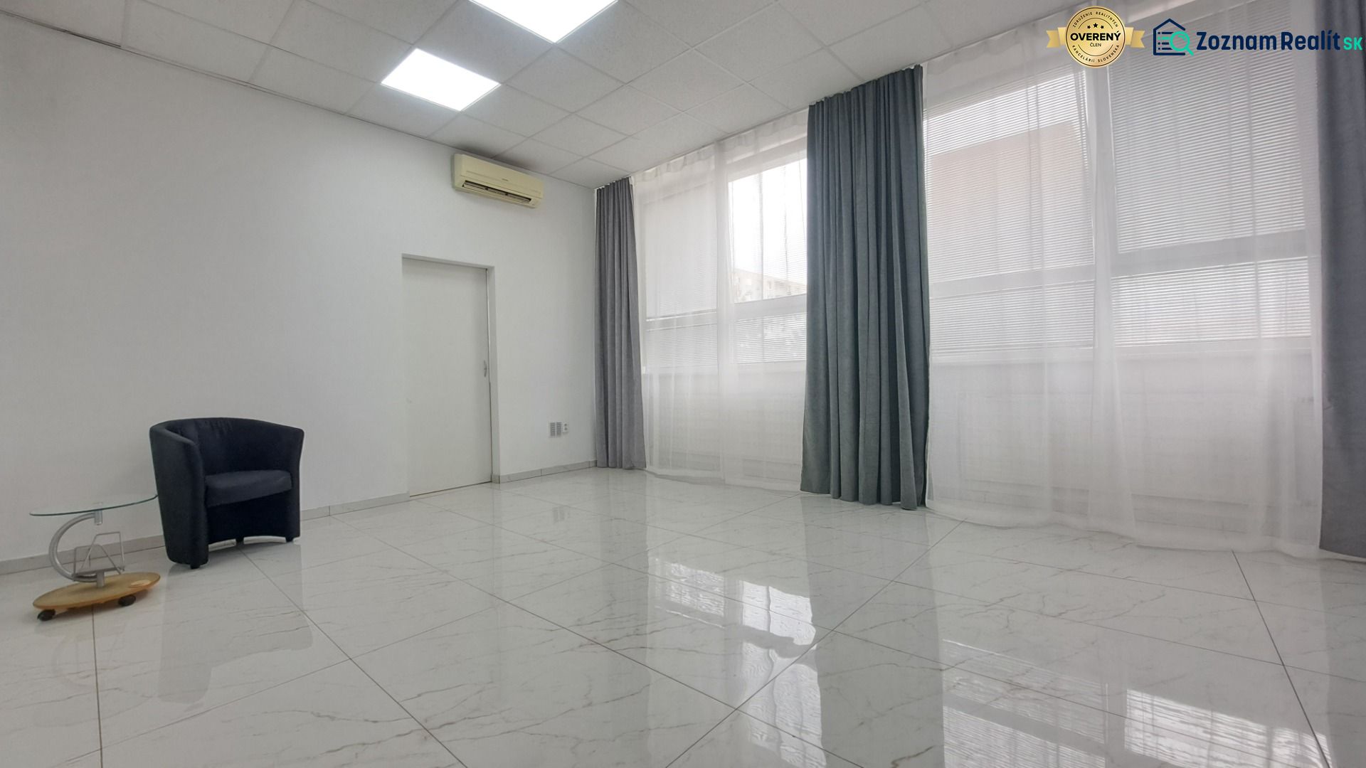 Stylish commercial spaces with white walls, ceramic flooring, an armchair, and a table.