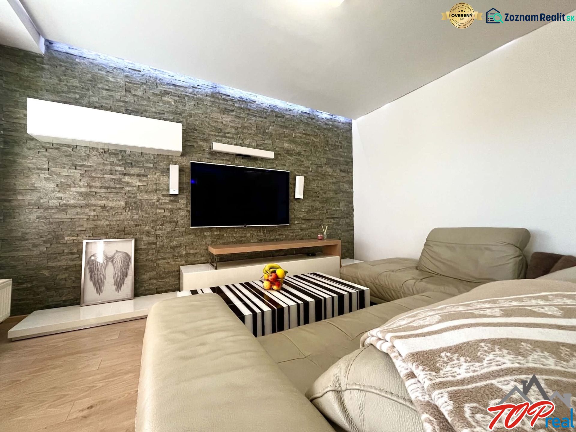 Living room in a 3-room apartment with a leather sofa and a wooden decor floor.
