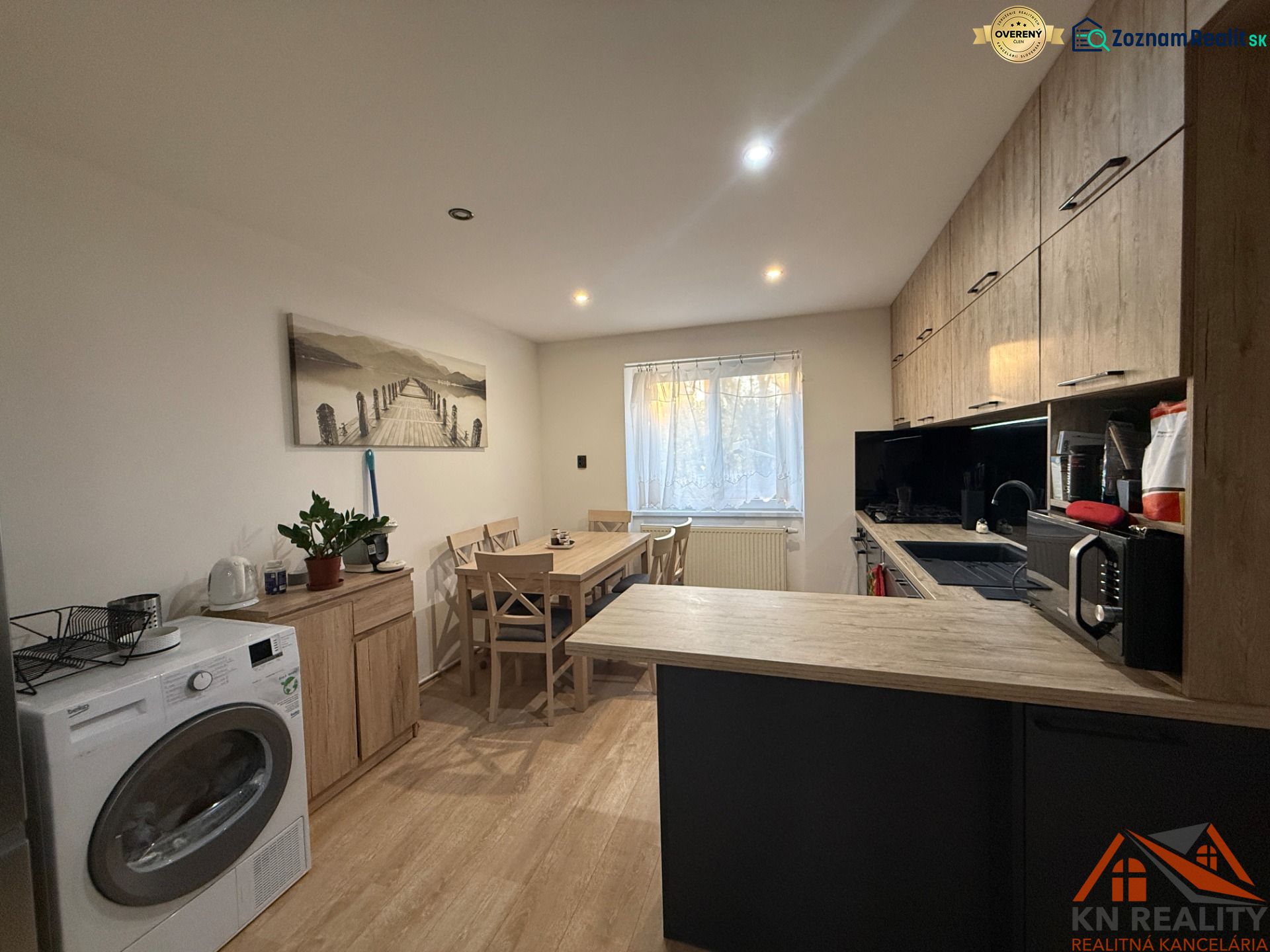 A kitchen in a 2-room apartment with a wooden decor floor and modern equipment.