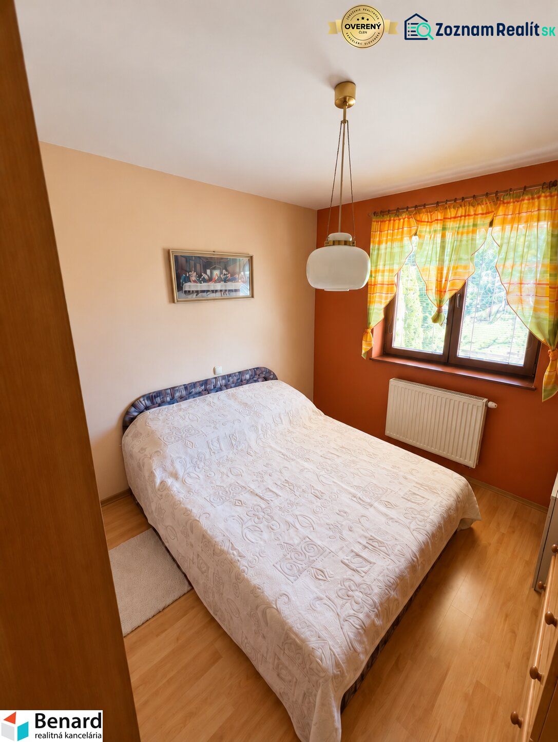 Bedroom in a family house with a bed, curtains, and a wooden decor floor.