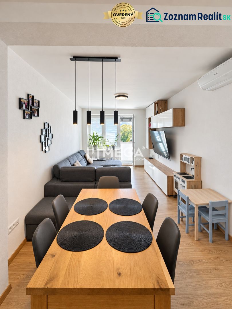 A spacious living room in a 3-room apartment with a wooden decor floor and a comfortable sofa.
