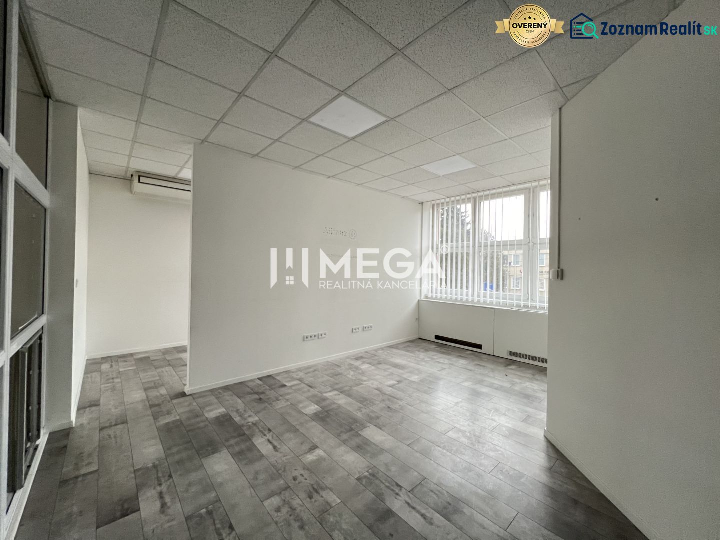 Offices with wood-patterned flooring, light-colored walls, and large windows.