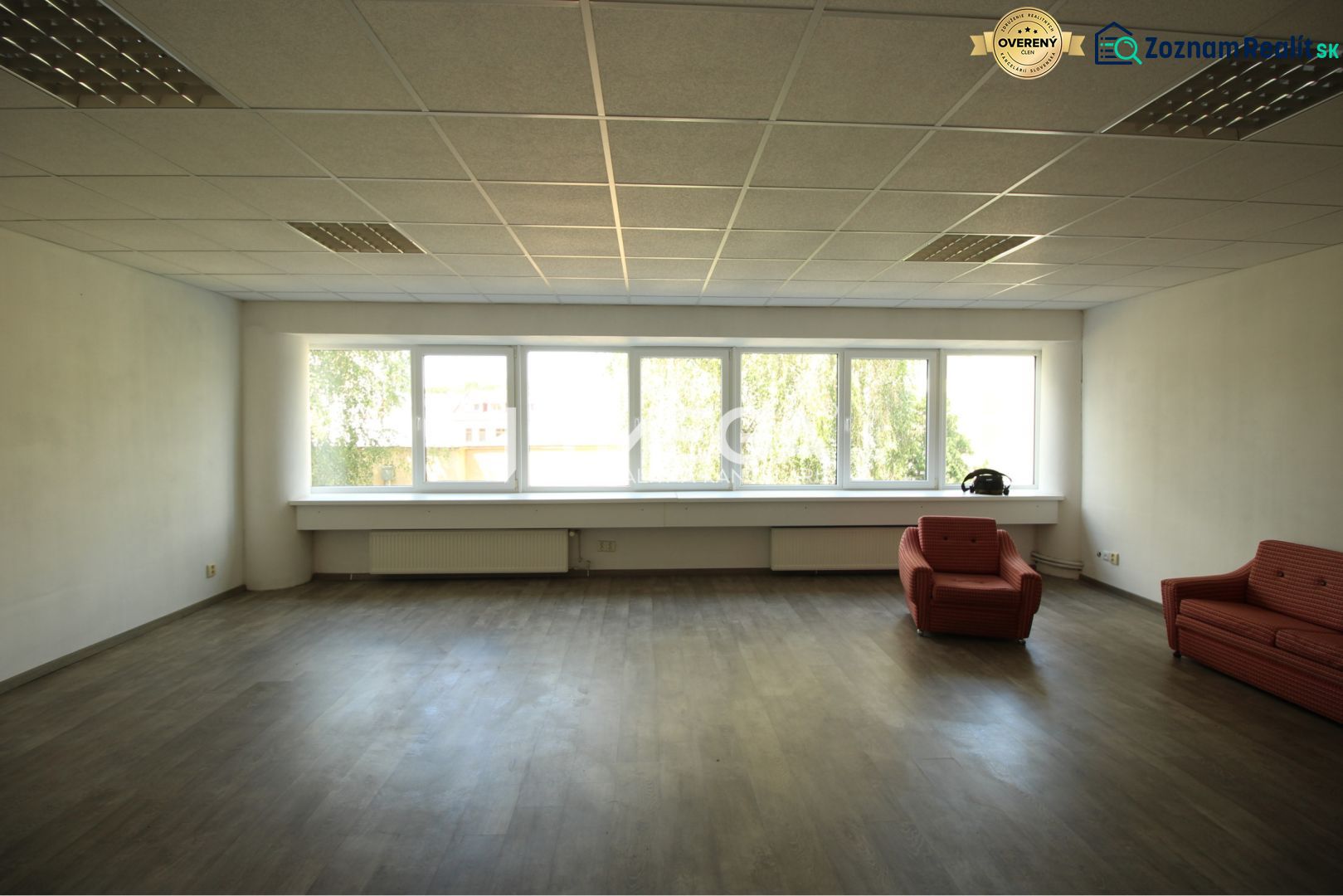 Offices with wood-patterned flooring and red chairs.