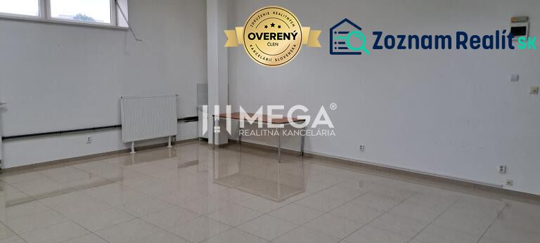 Spacious offices with white walls and tiles, a dining table, a radiator by the window.