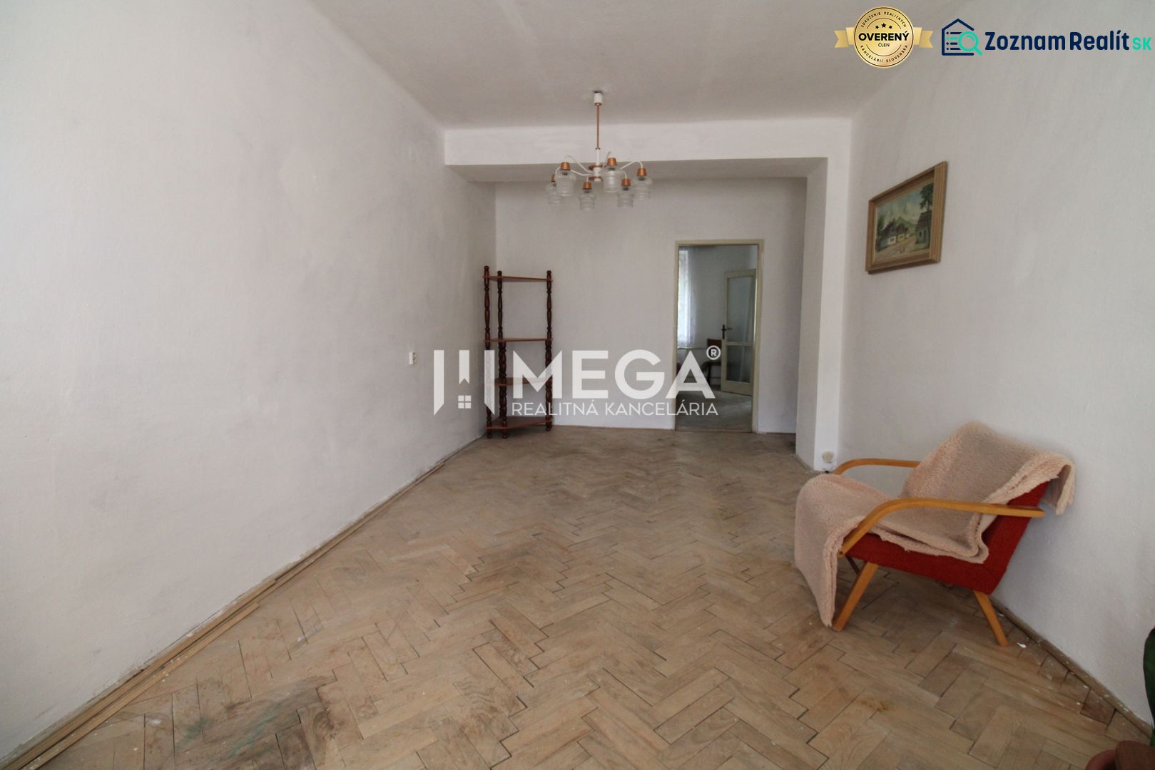 Living room with an old armchair and a floor with a wooden decor in a 2-room apartment.