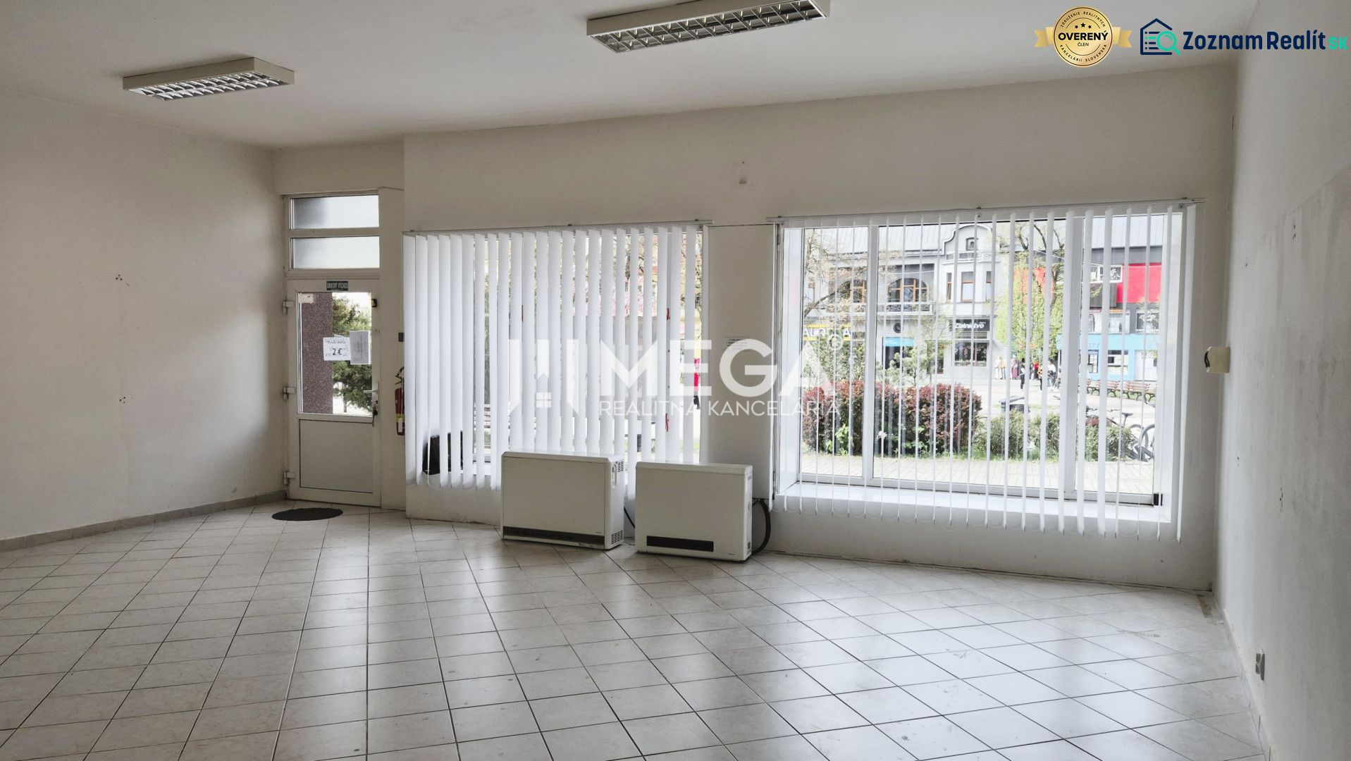 Interior of commercial premises with large windows and tiled floor.