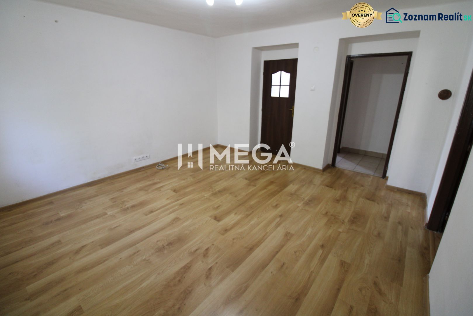 A room in a 3-room apartment with a wooden decor floor and white walls.