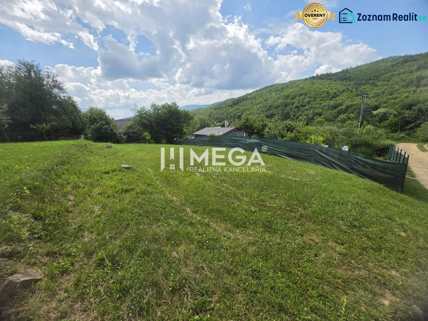 Gardens with green lawns in Snina on Snina Street surrounded by wooded hills.