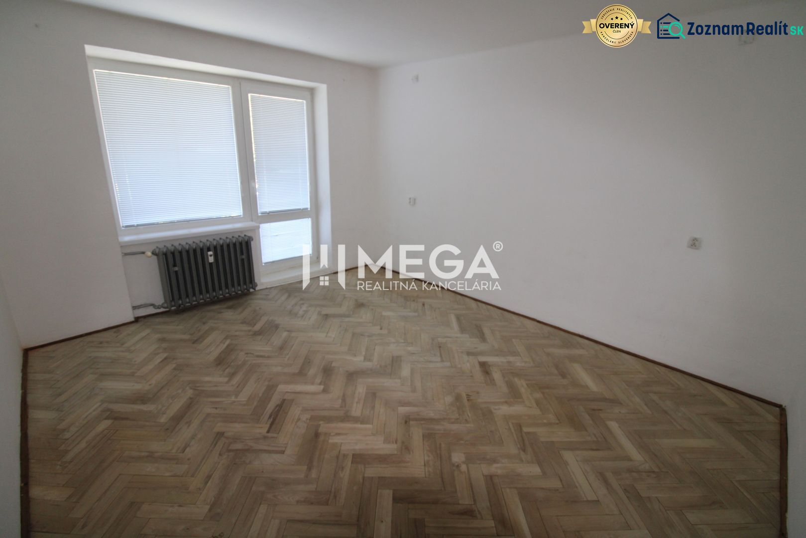 A spacious room in a 2-room apartment with a wooden decor floor and a radiator.