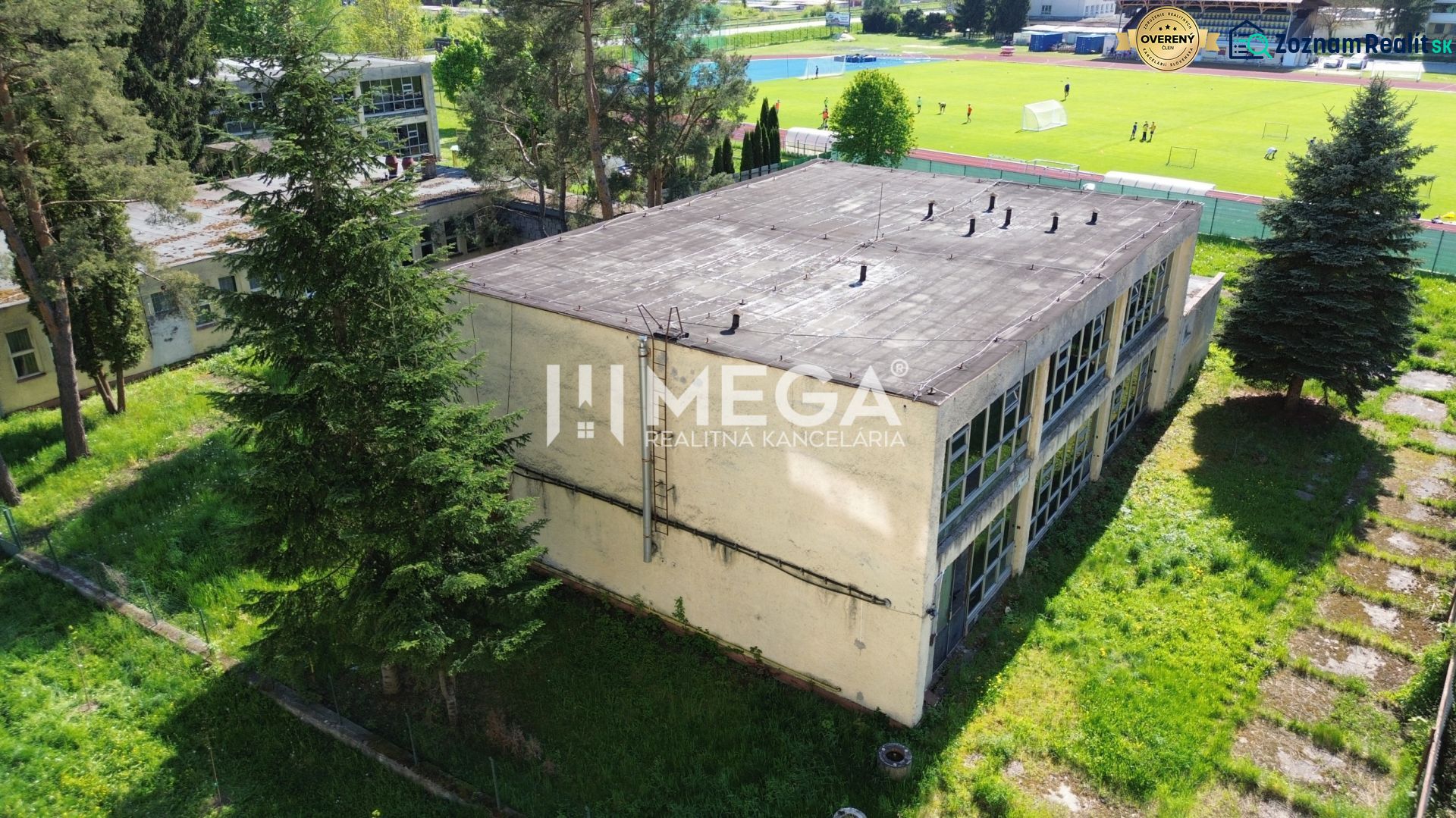 A building on Tyršova Street in Humenné surrounded by trees and a lawn with a playground in the background.