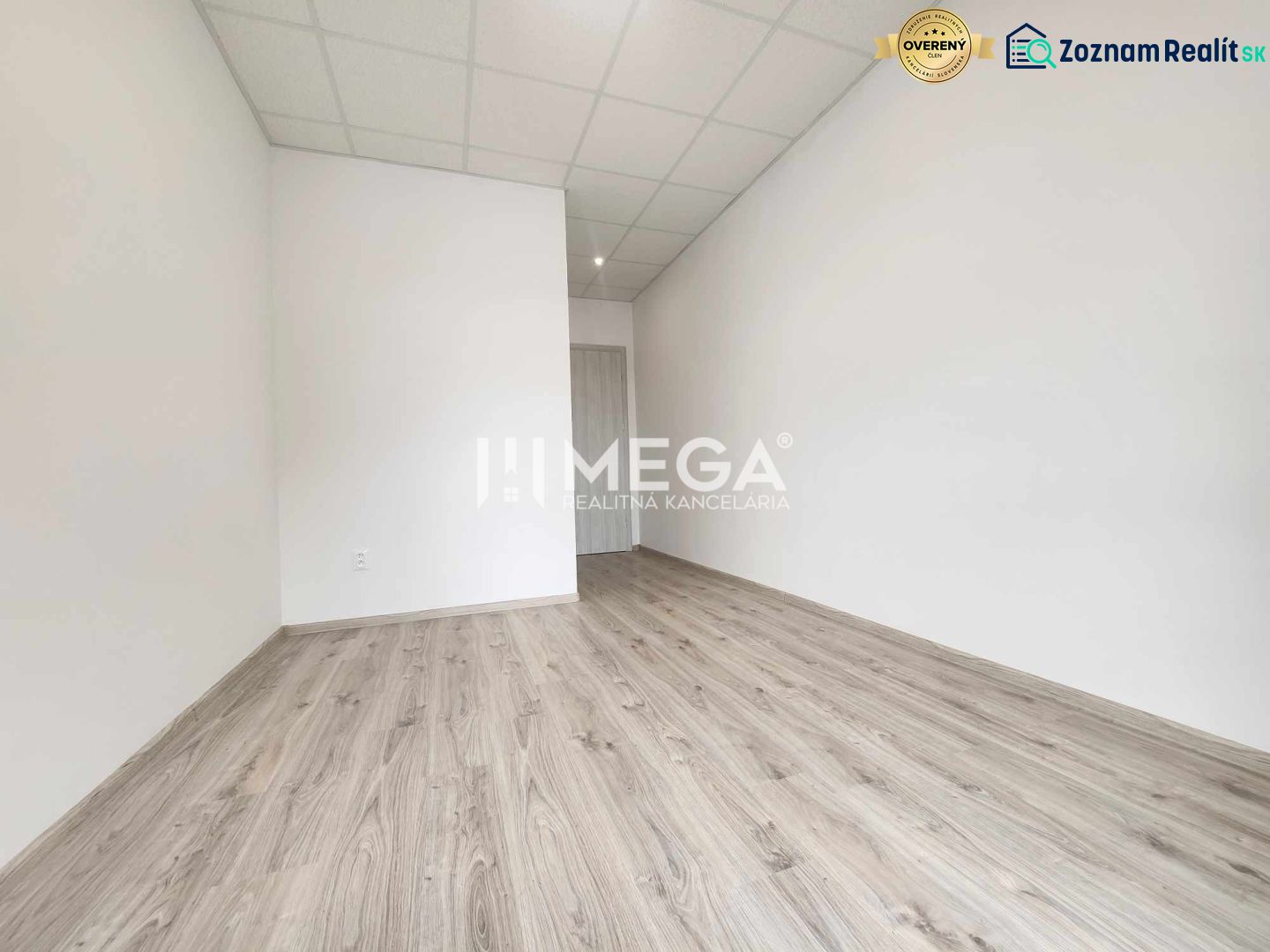 A bright office with wood-patterned flooring and white walls.