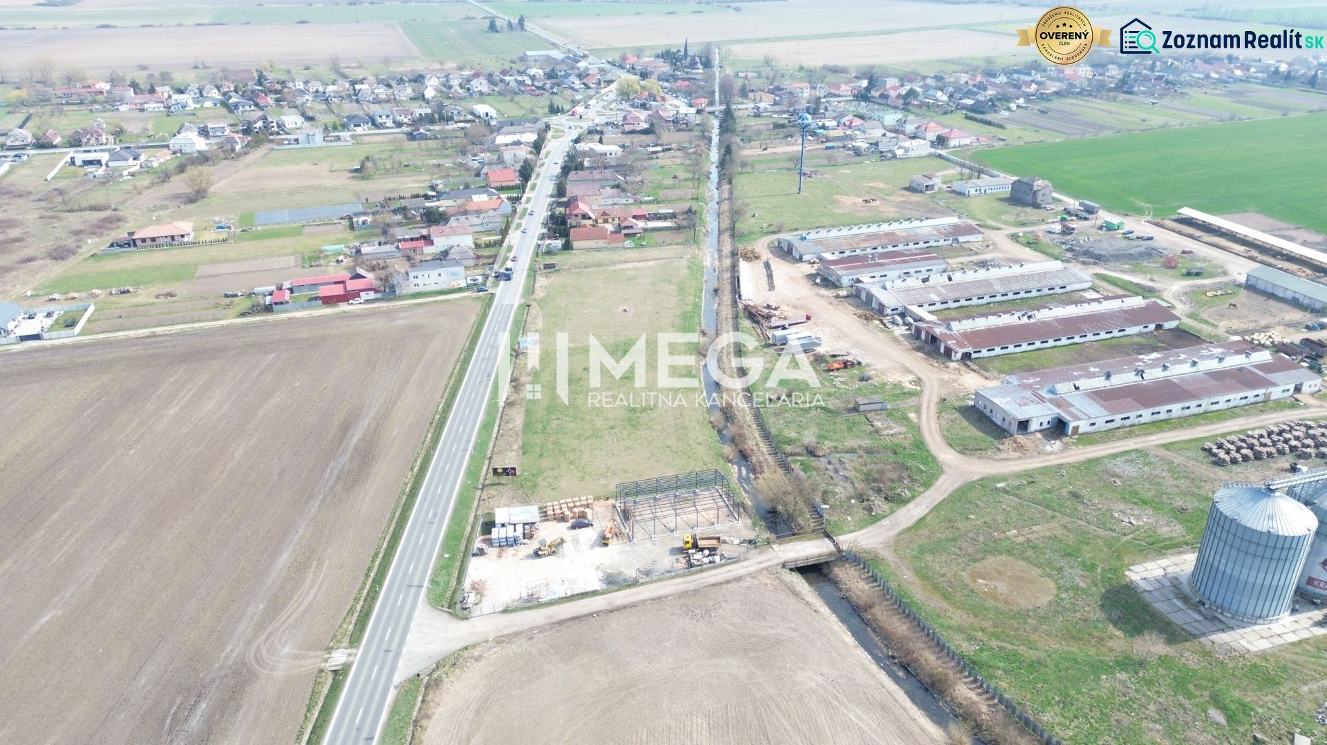 Aerial view of manufacturing facilities in the village of Hriadky surrounded by agricultural fields and a road.