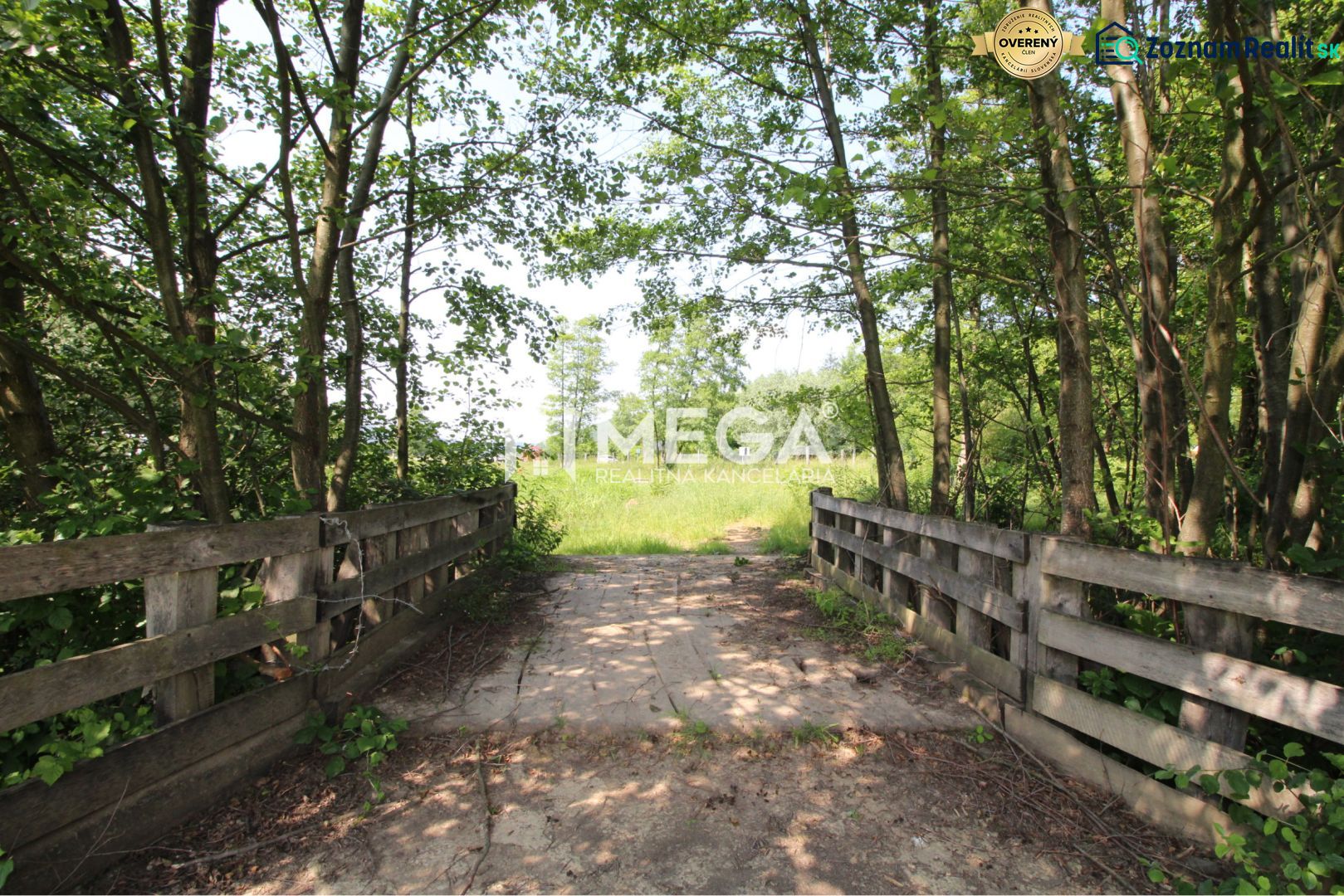 A forest path over a small bridge surrounded by greenery in Ptičí, Land - residential.