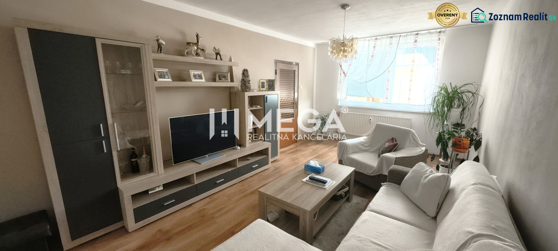 Living room with a sofa, television, and floor with wooden decor in a 4-room apartment.
