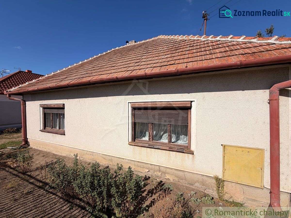 A family house in Hurbanovo with a white facade and a sloped roof on a sunny plot.