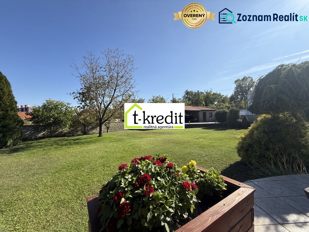 The garden of a family house in Zlaté Moravce with blooming flowers and trees.