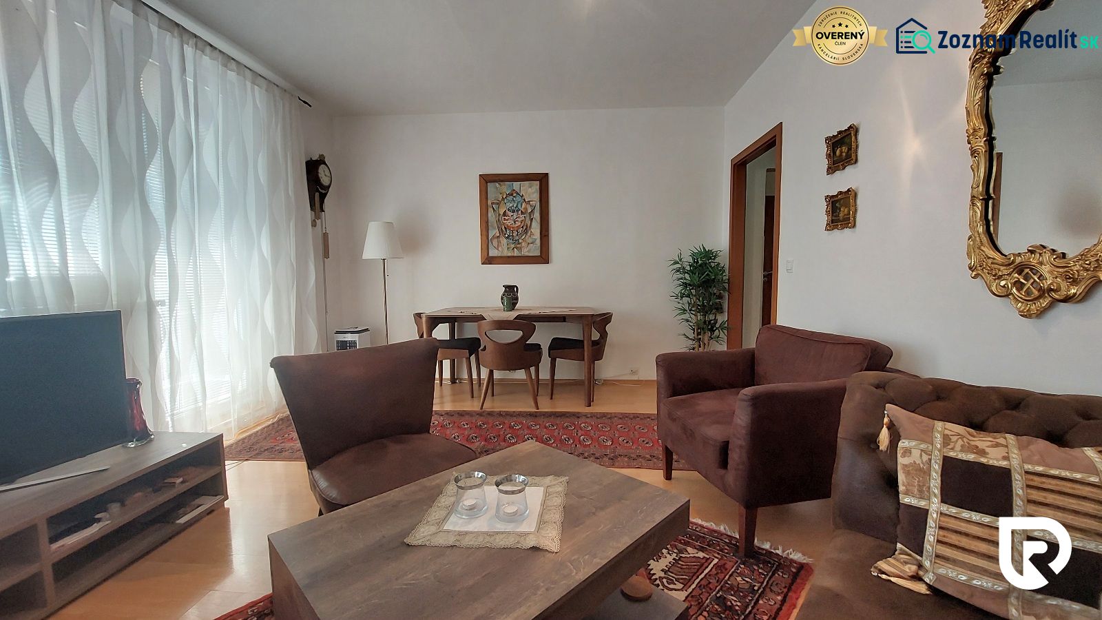 Living room in a three-room apartment with a wooden decor floor, comfortable seating, and decorations.
