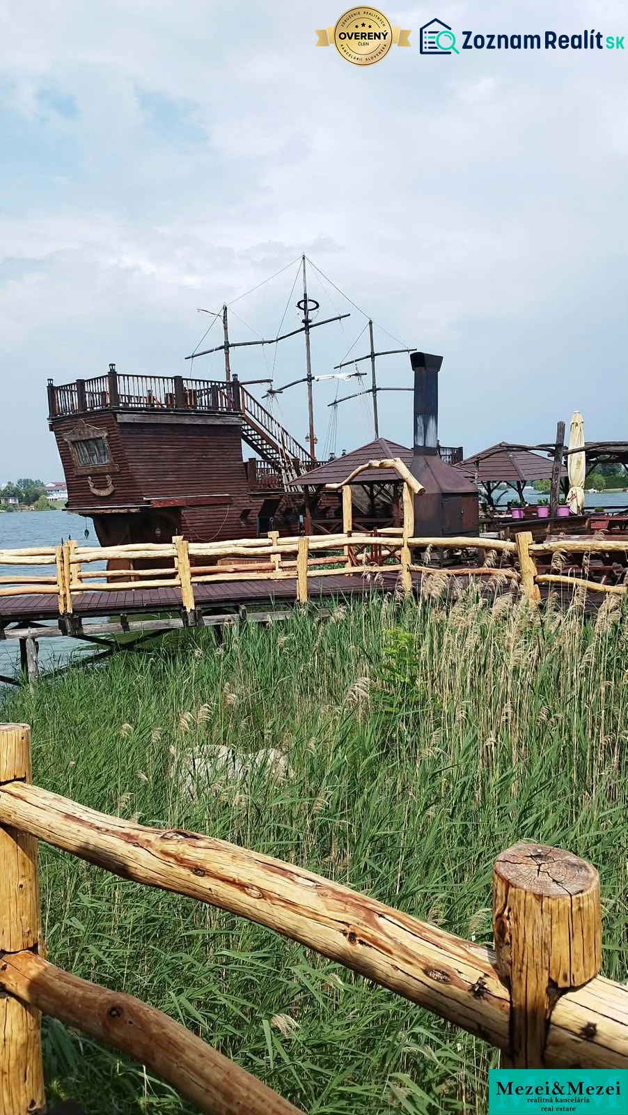 A wooden boat as an attraction at the cottage on the Senec Lakes, behind a wooden fence.