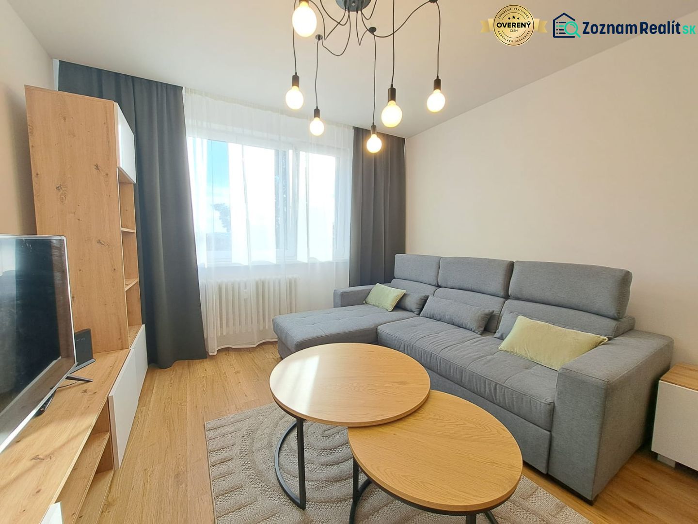 A bright living room in a two-room apartment with a comfortable sofa and a wooden decor floor.