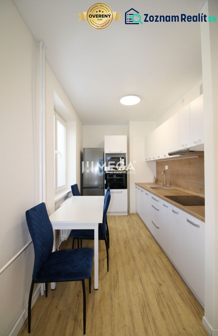 A kitchen with white cabinets and a wood-patterned floor in a 2-room apartment.