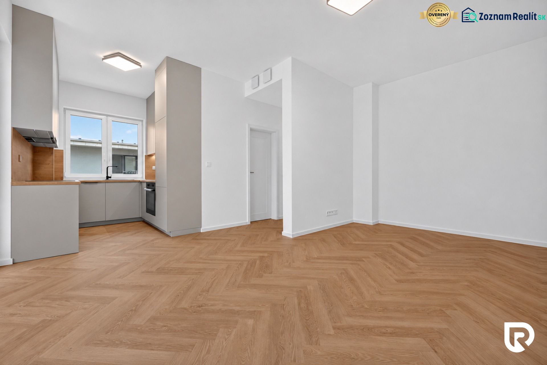 A kitchen with a built-in unit and a wooden decor floor in a 3-room apartment.