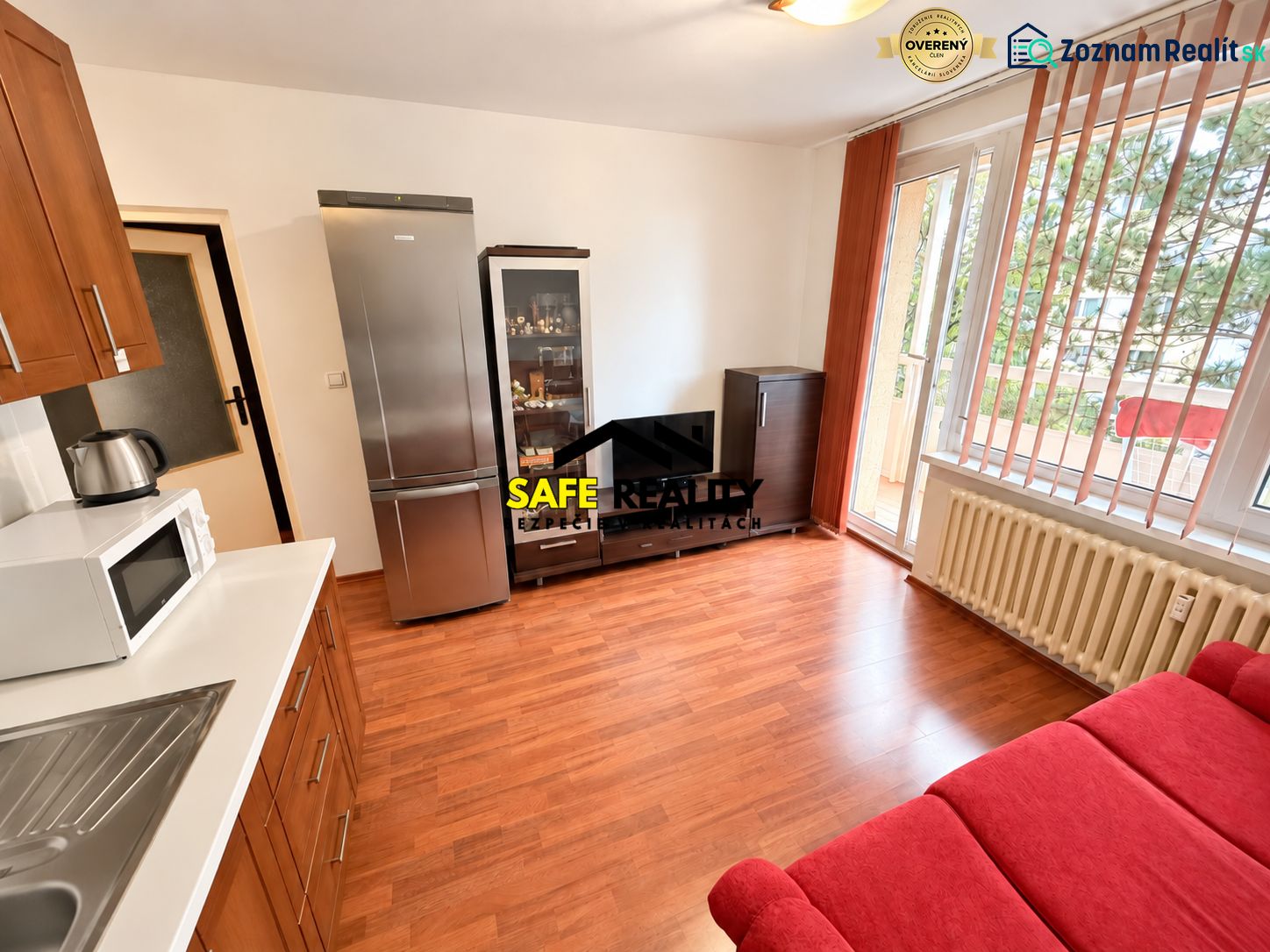 Living area of a studio apartment with a wooden decor floor and access to a balcony.