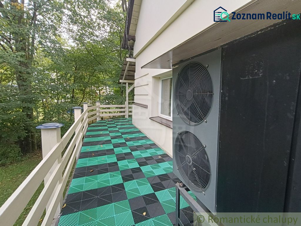 A family house in Staškov has a terrace with colorful tiles and surrounding trees.