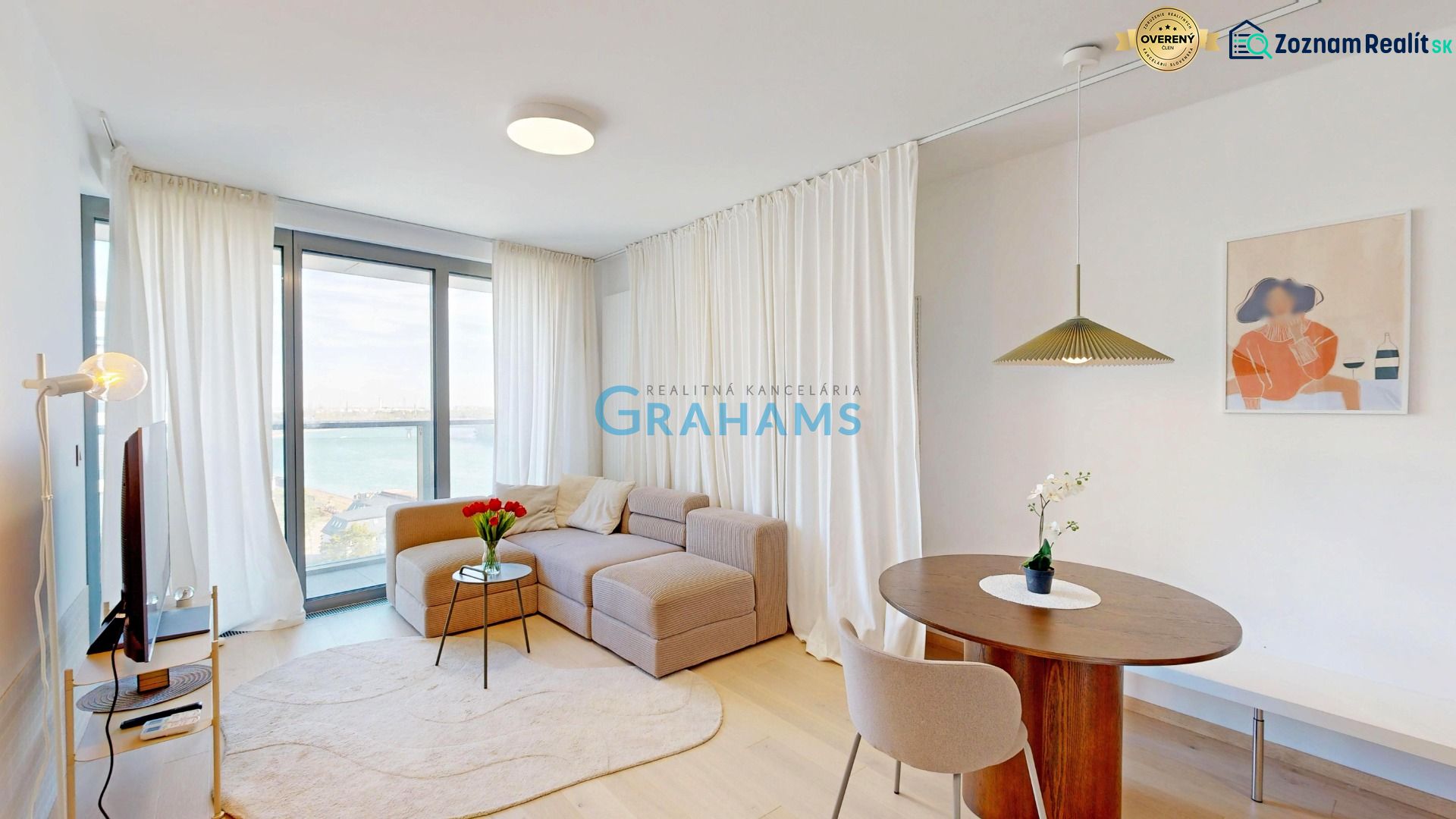 Living room in a two-room apartment with a sofa, table, and wooden decor flooring.