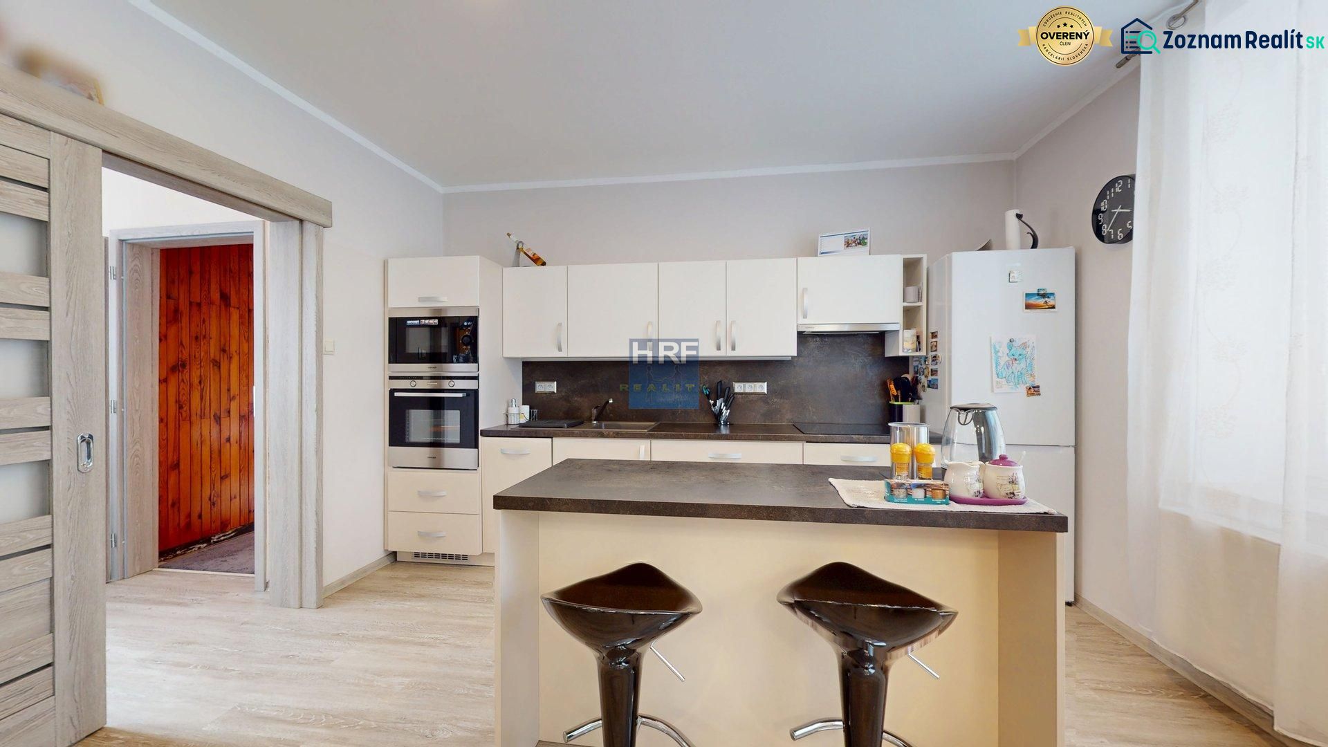 A kitchen in a family house with a wooden decor floor and modern appliances.