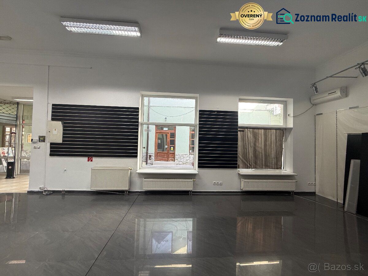 Commercial space with a gray floor and a large window.