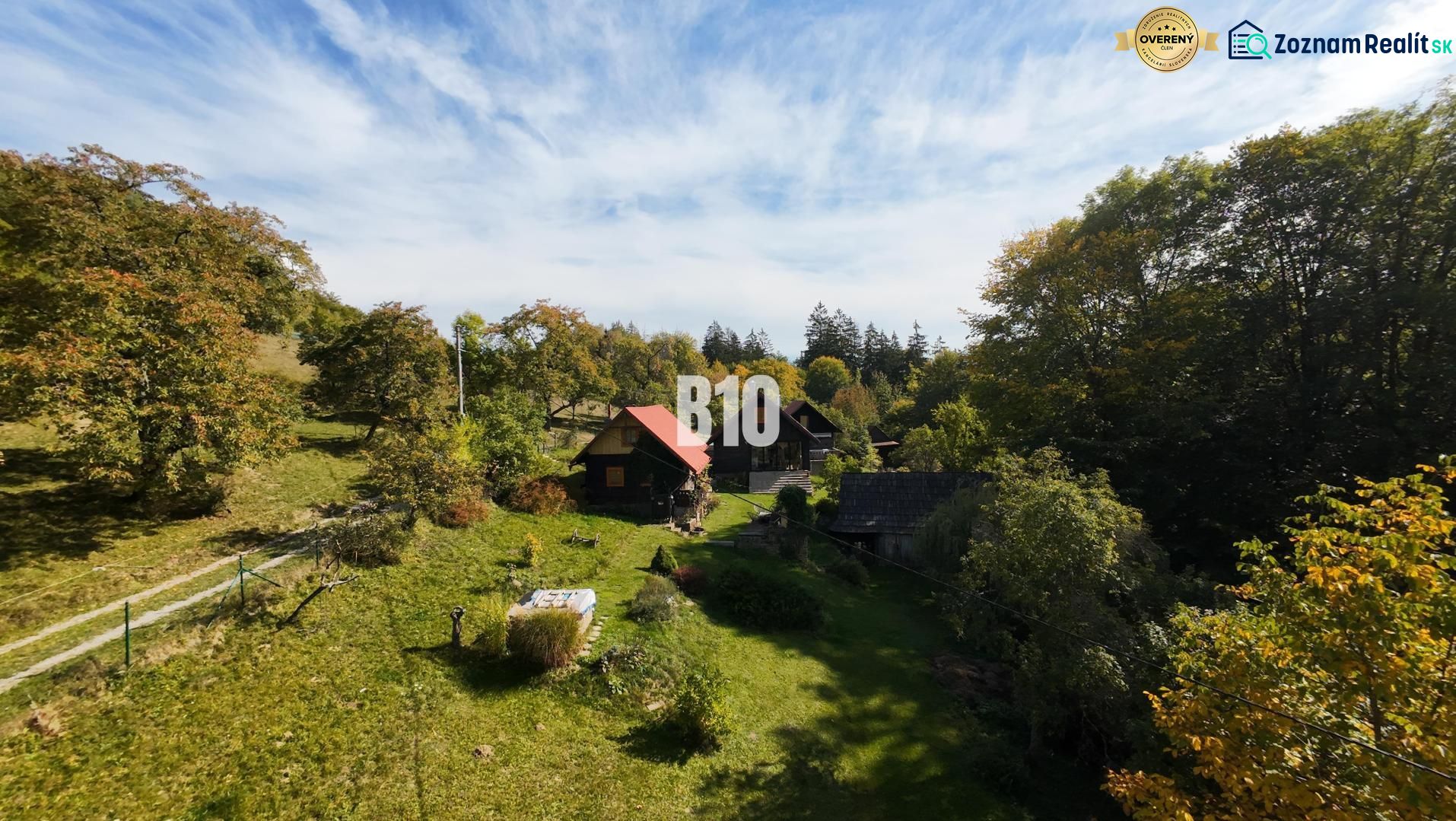 A cottage in Dlhé Pole amidst a forest landscape with a blue sky.