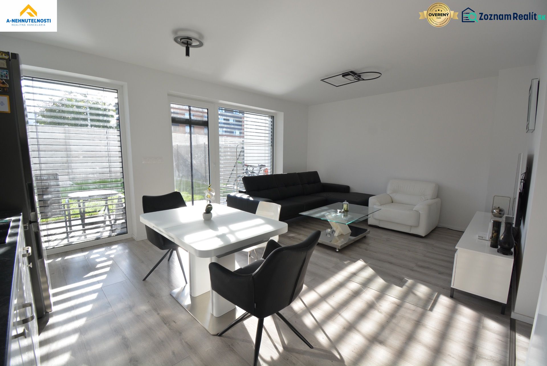 Living room in a 3-room apartment with a wooden decor floor and large windows.