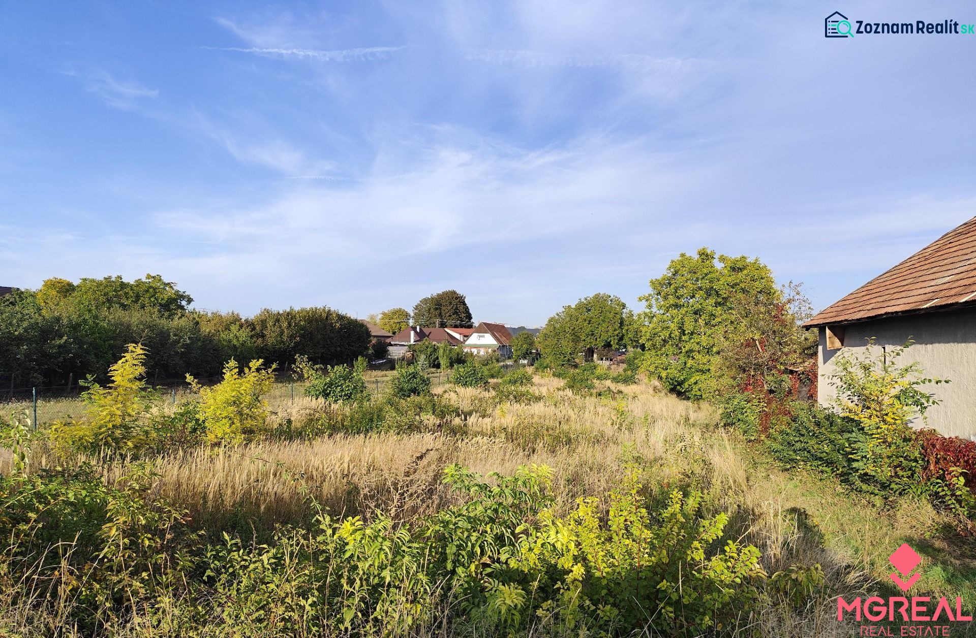 Plots - housing in Jasová, surrounded by greenery with visible buildings in the background.