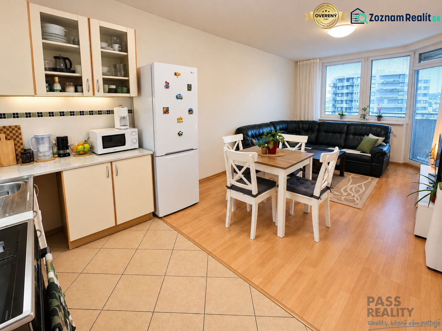 Kitchen and living room in a 2-room apartment with a wooden decor floor, dining table, and sofa.