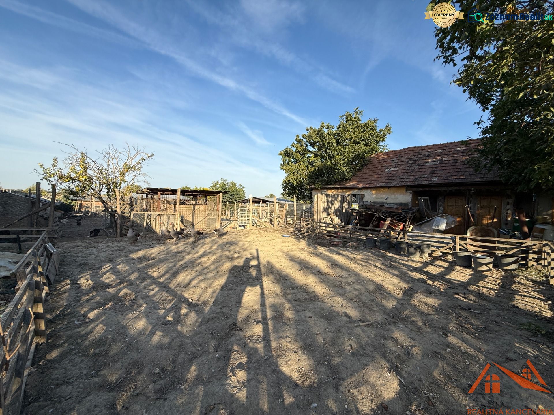 The courtyard of a family house in Komárno, an enclosed area with trees and older buildings.