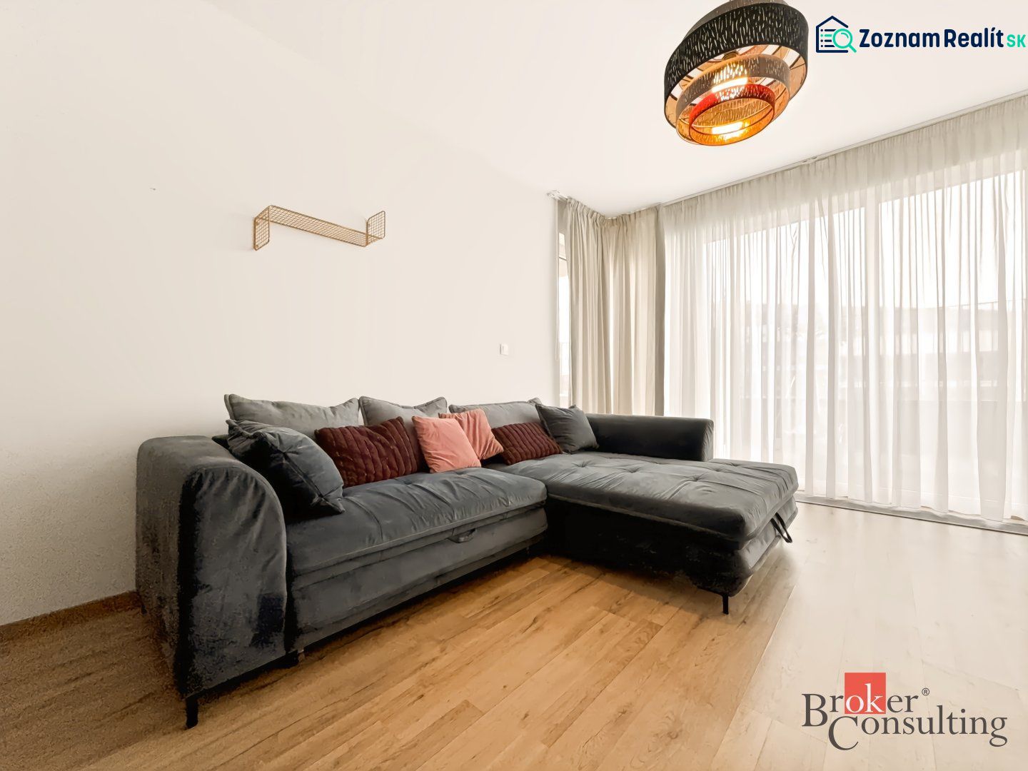 Living room in a two-room apartment with a corner sofa and a wooden decor floor.