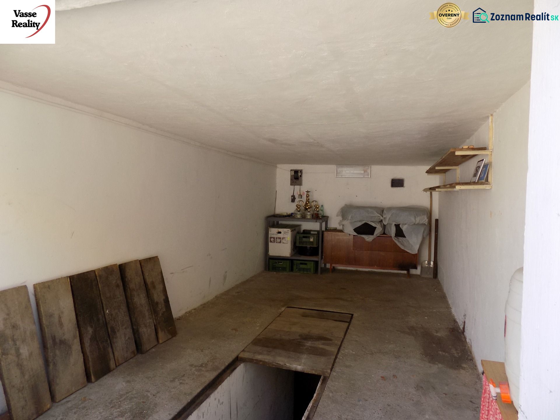Garage with shelves, road floor, racks, and stored items.