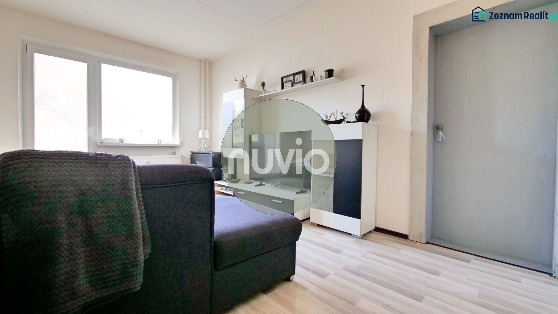 A view into the living room with a wooden decor floor in a 2-room apartment.