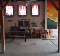 Interior of commercial spaces with furniture, wooden columns, and an artistic mural on the wall.