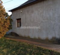 An old building next to the sidewalk on Hlavná in the Váhovce shopping zone.